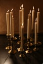 Burning candles in retro candlesticks indoor. Royalty Free Stock Photo