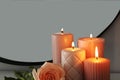 Burning candles and rose near mirror in room, closeup. Space for text Royalty Free Stock Photo