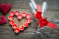 Burning candles in the shape of heart with two flutes Royalty Free Stock Photo