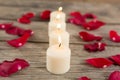 Burning candles surrounded with aromatic rose petals