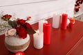 Burning candles and vase with flowers on red table indoors. Valentine`s Day celebration Royalty Free Stock Photo