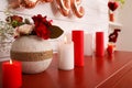 Burning candles and vase with flowers on red table indoors. Valentine`s Day celebration Royalty Free Stock Photo