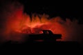 Burning car on a dark background. Car catching fire, after act of vandalism or road indicent