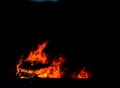 Burning car on the road at night, a tragic accident ending with Royalty Free Stock Photo