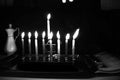 Burning Chanukah. The lit Chanukiah. Jewish holiday Hanukkah. Black and white photo. Porcelain jug with oil.