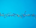 Burning christmas garland on a white wire with colorful lights on a blue background Royalty Free Stock Photo