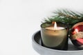 burning christmas green candle on a concrete tray next to new year decor. hcopy space, home scents for cozy atmosphere. Royalty Free Stock Photo