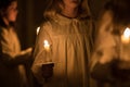 burning church candles in the hands of children on a dark background