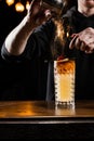 Burning cinnamon in cocktail. Bartender pours and fire burns cinnamon in alcoholic cocktail at a bar. Bartender is Royalty Free Stock Photo
