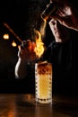 Burning cinnamon in cocktail. Bartender pours and fire burns cinnamon in alcoholic cocktail at a bar. Bartender is Royalty Free Stock Photo