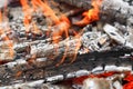 Burning coals with a white ash and red flames