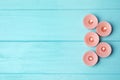 Burning decorative candles on light blue wooden table, flat lay.