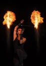 Burning desire. Sensual woman twirl flaming baton in darkness. Fire performance.