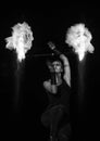 Burning desire. Sensual woman twirl flaming baton in darkness. Fire performance.