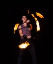 Burning energy. Handsome man juggle flaming batons. Fire juggling. Fire energy. Energetic twirling. Flame and sparks