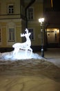 Burning figure of a deer in a quiet winter evening against the background of a historic building