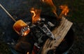 burning fire in compact grill, wood logs engulfed red flames, closeup of metal grill on burning coals, aromatic smoke rises Royalty Free Stock Photo