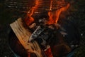 burning fire in compact grill, wood logs engulfed red flames, closeup of metal grill on burning coals, aromatic smoke rises Royalty Free Stock Photo