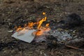 Burning in the fire of a torn notebook. The cover and the multi-colored sheets burn into gray ash Royalty Free Stock Photo