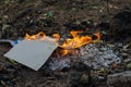 Burning in the fire of a torn notebook. The cover and the multi-colored sheets burn into gray ash Royalty Free Stock Photo
