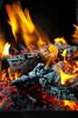 Burning fire wood and smoldering embers close view abstract background Royalty Free Stock Photo