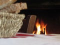Burning fireplace with basket of bread and old vintage chair in a country atmosphere