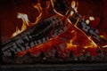 Burning firewood logs inside metal fireplace stove with open flames glowing embers and ash during heating process Royalty Free Stock Photo