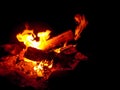 Burning firewood at night. Bonfire in a camping camp in nature in the mountains. Flames and fiery sparks on a dark Royalty Free Stock Photo
