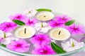 Burning floating candles with pink flowers in a bowl of water, spa relaxation and meditation Royalty Free Stock Photo