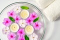 Burning floating candles with pink flowers in a bowl of water and two white towels, spa relaxation, body care and Royalty Free Stock Photo