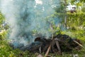 Burning garbage. grass and leaves burns in the garden. Fire and Smoke from during Burning of garden waste. Garbage in fire. Royalty Free Stock Photo