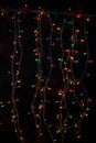 Burning garland in the dark. Light bulbs of garlands. Multicolored Lights on a black background. Christmas mood. Good New Year Royalty Free Stock Photo