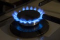 Burning gas stove hob blue flames close up in the dark on a black background Royalty Free Stock Photo