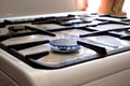 A burning gas stove on a white kitchen stove