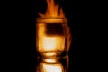 burning glass of alcohol with ice on a black background