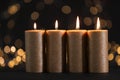 Burning gold candles against blurred lights Royalty Free Stock Photo