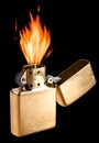 Burning golden metal gas lighter on black background Royalty Free Stock Photo