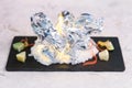 Burning grilled clams the wrap by foil, burn with salt served with sliced lime on black rectangle plate on washi Japanese paper