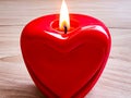 A burning heart-shaped red candle. Generative AI