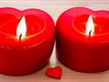 A burning heart-shaped red candles. Generative AI