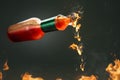 Burning hot chili sauce dripping from a bottle Royalty Free Stock Photo
