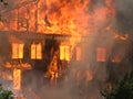 Burning house. Big wooden building completely destroyed by fire Royalty Free Stock Photo