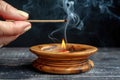 Burning Incense Stick in a Wooden Holder on a Black Table, Aromatherapy and Relaxation Concept