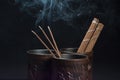 Burning incense sticks and brown bowl on black background. Beautiful smoke from above Royalty Free Stock Photo