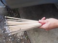 Burning incense sticks holding on a hand with waving smoking Royalty Free Stock Photo