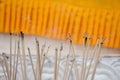 Burning incense sticks and smoke in an incense pot with yellow fabric. Royalty Free Stock Photo