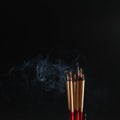 Burning incense white smoke black background used as a worship background image a sacred object of Buddhist beliefs focuses on the