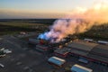 Burning industrial building with fire, huge thick smoke and burnt roof, aerial view Royalty Free Stock Photo