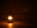 Burning kerosene lamp in the dark on the floor, light and hope, copy space