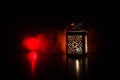 Burning lantern in the dark. Ornamental lantern with burning candle glowing at night. Wth a lot of empty space. Red orange fire ba Royalty Free Stock Photo